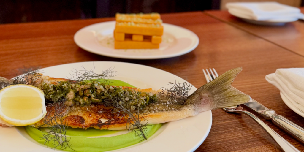 Whole whiting served with pea puree and chickpea chips by Orson Dining.