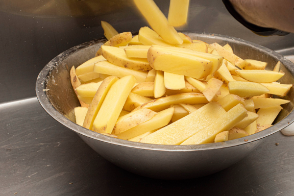 Potatoes being cut into chips