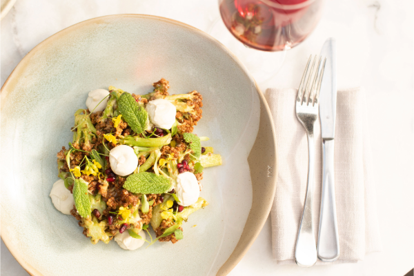 A dish of golden cauliflower florets dotted with pillows of cashew cream and little jewels of pomegranate.